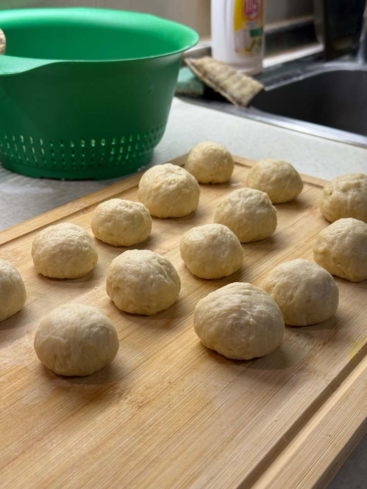 Rows of dough balls on a wooden board